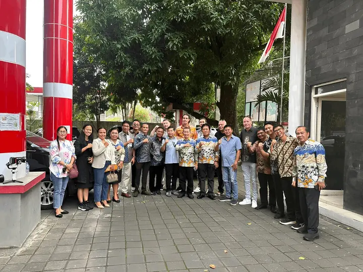 A group of people, including ESMI staff, posing outside a government office building.